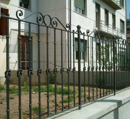 Davanti a un edificio c'è una recinzione in ferro battuto
