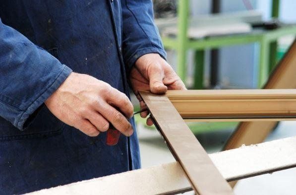 Un uomo sta tagliando un pezzo di legno con un cacciavite