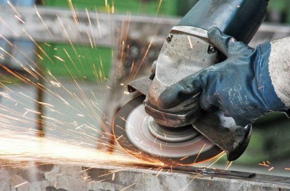 Una persona sta macinando un pezzo di metallo con una smerigliatrice.