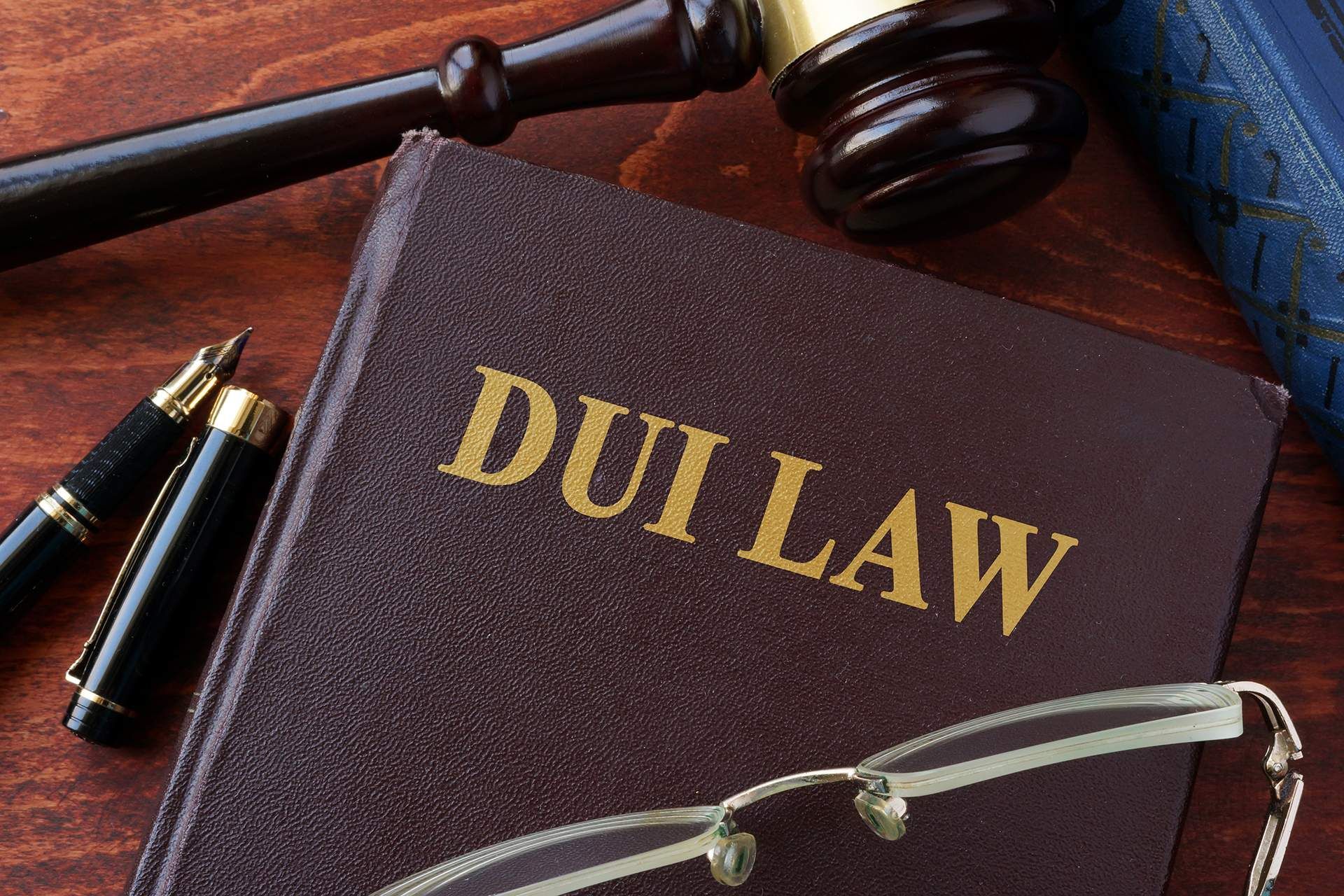 A judge 's gavel is sitting on a wooden table next to a stack of books.