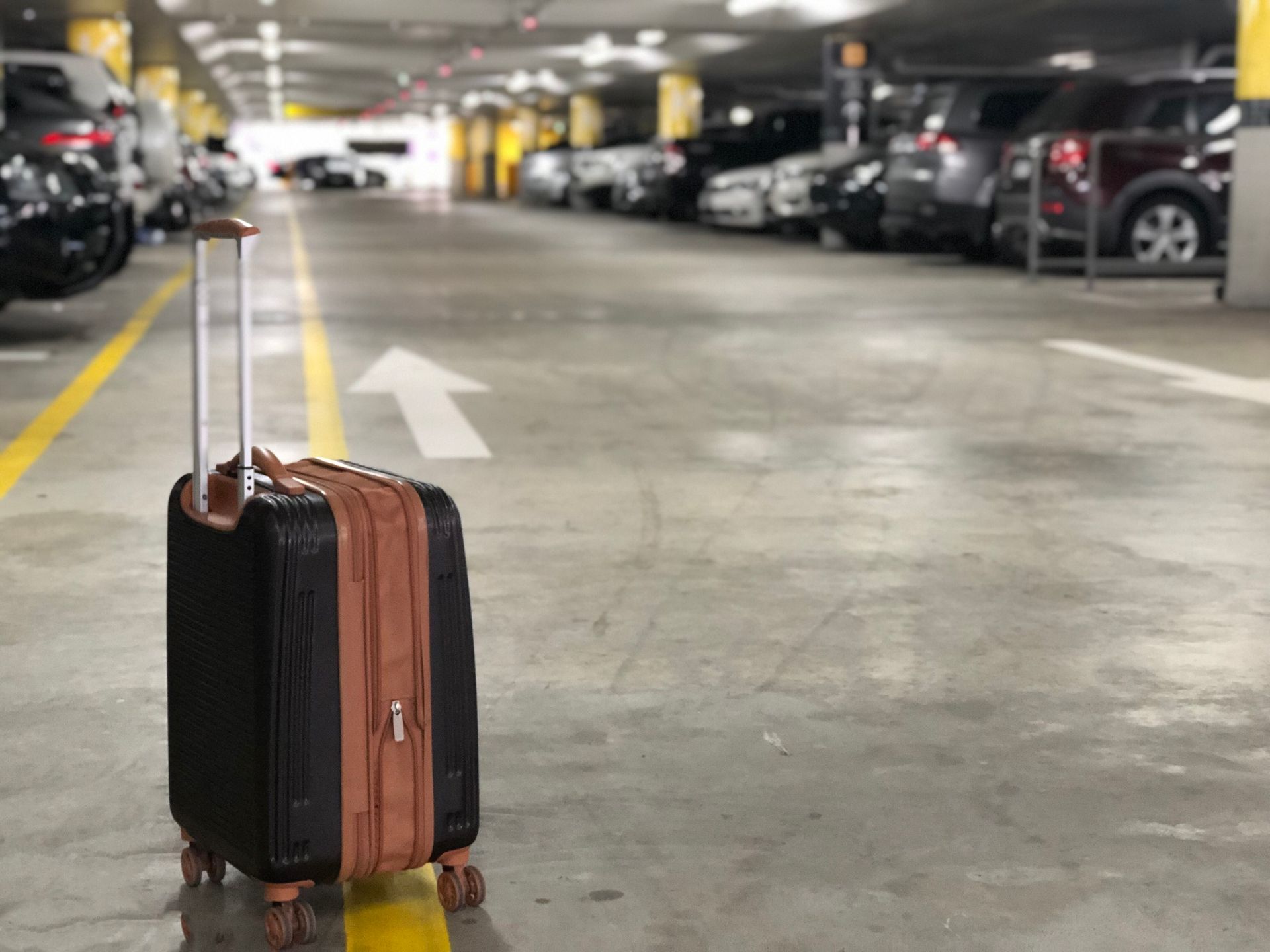 A suitcase is sitting in the middle of a parking garage