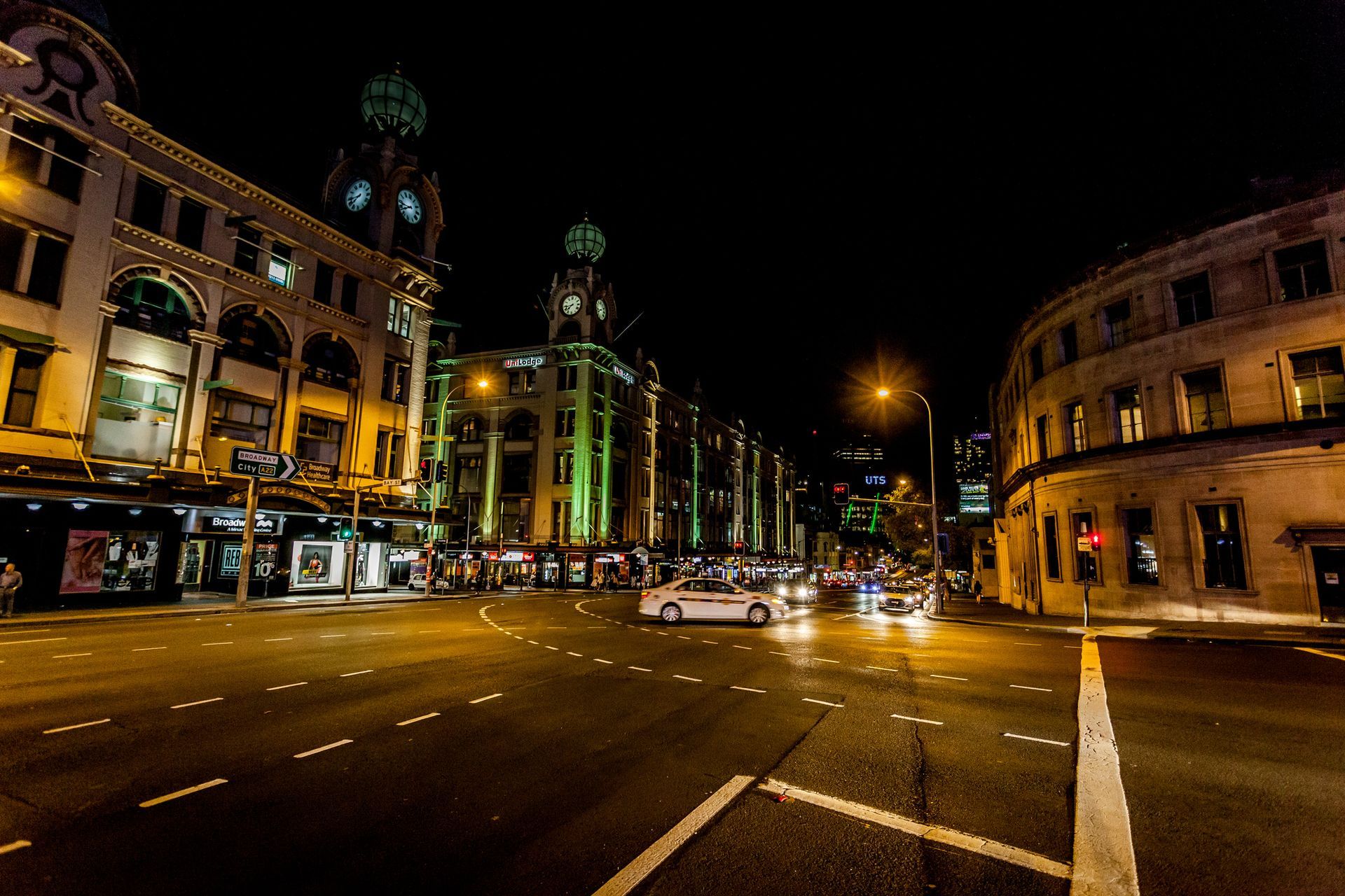 A city street at night with a clock tower in the background