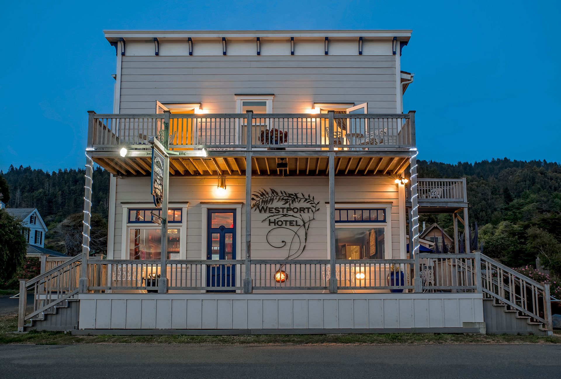 A large white building with a blue door and stairs