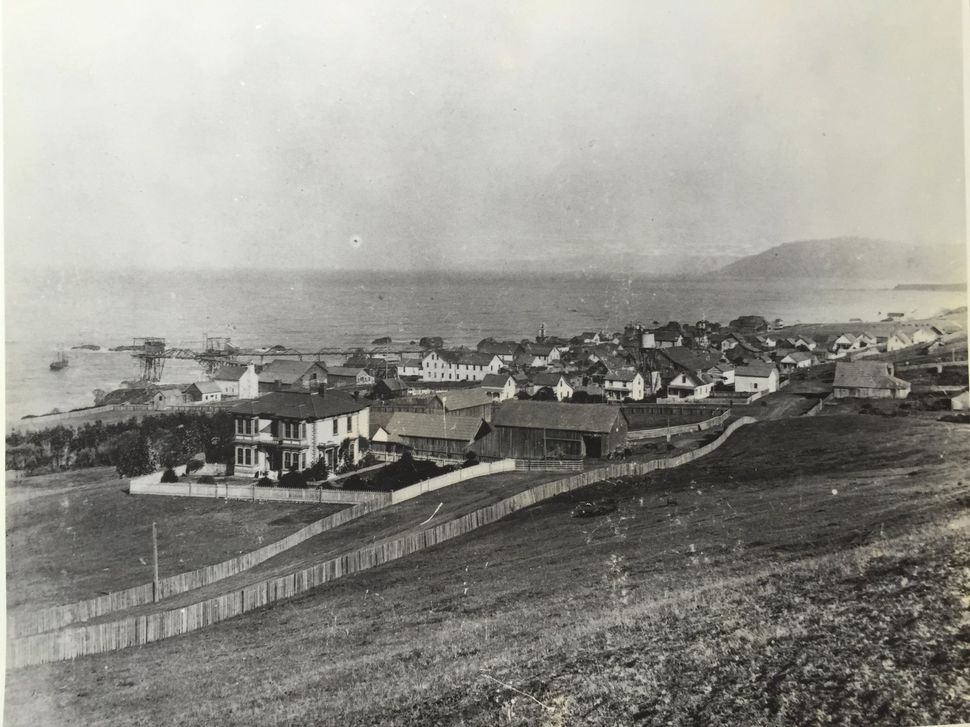 A black and white photo of a small town near the ocean