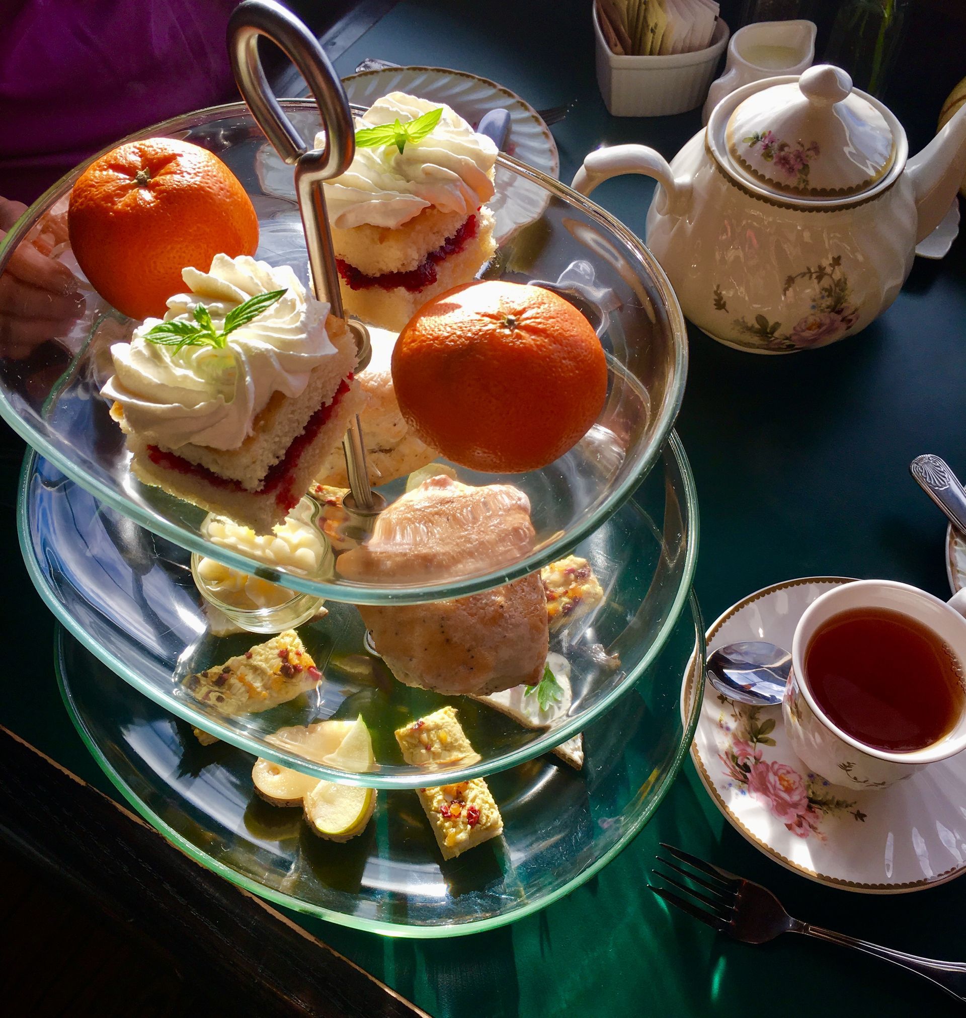 A teapot and two cups of tea are on a table.