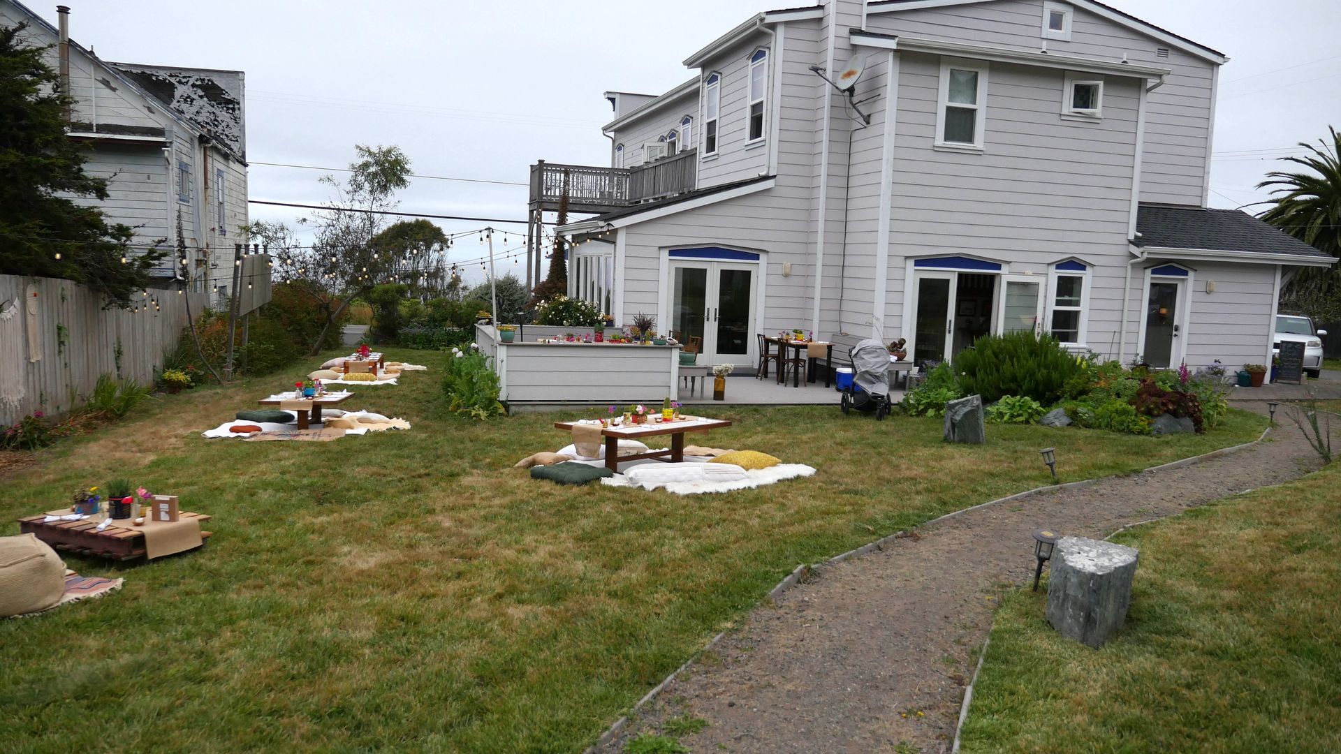 A large white house with a picnic area in front of it.