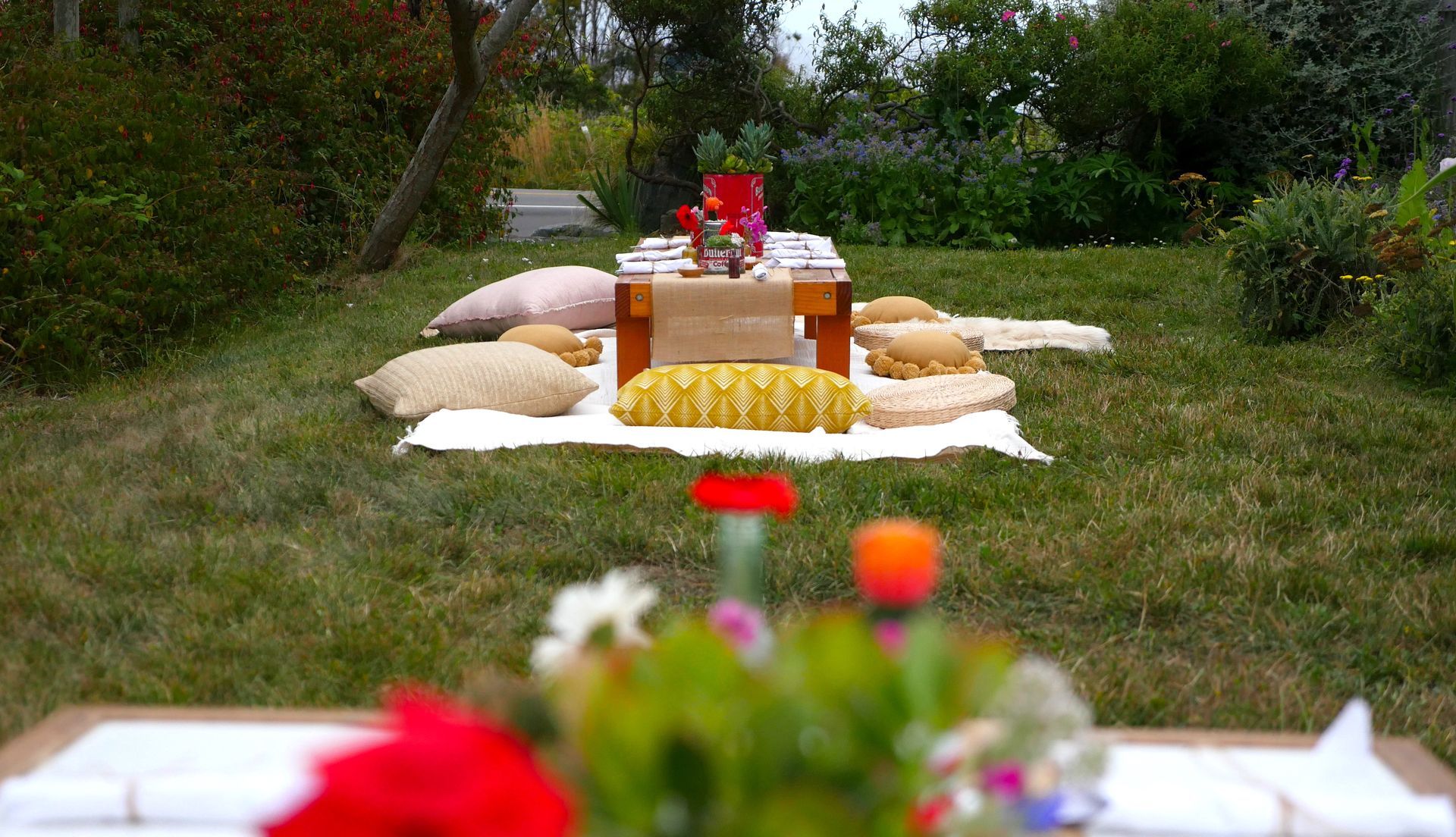 A picnic table is sitting on top of a blanket in the grass.