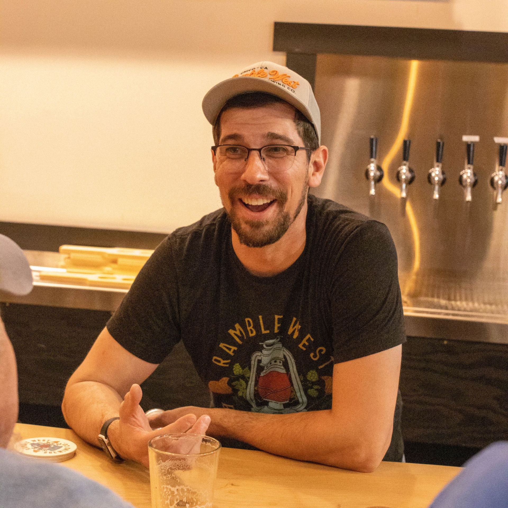 A man wearing a ramble west shirt sits at a table