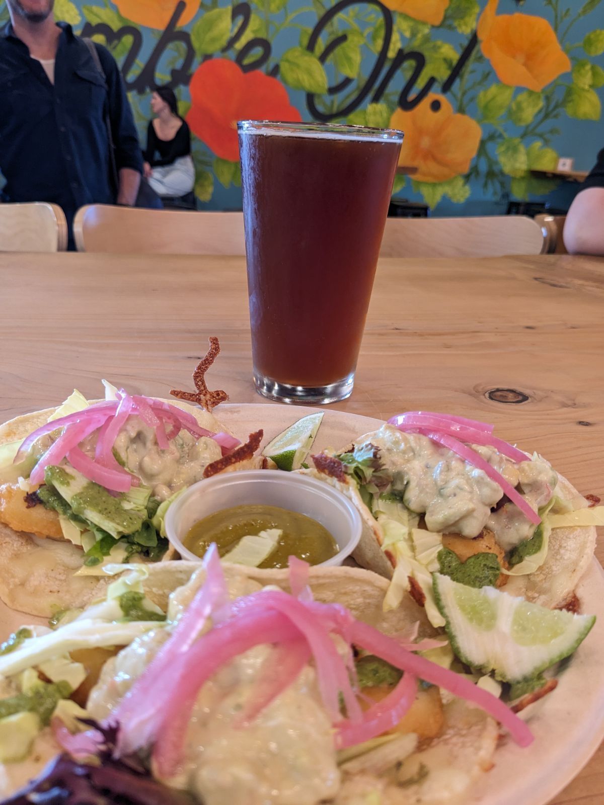 A plate of food and a glass of beer on a table.
