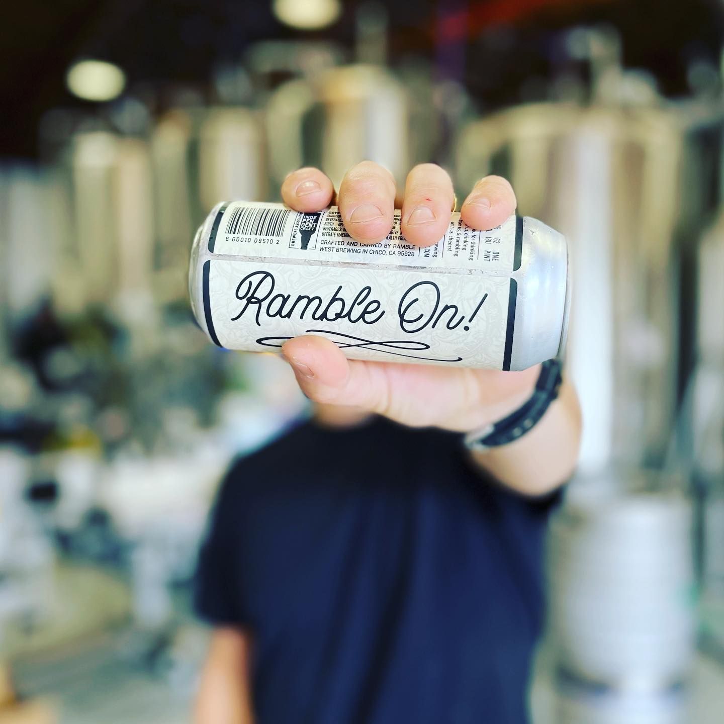 A person is holding a can of ramble on in front of their face.