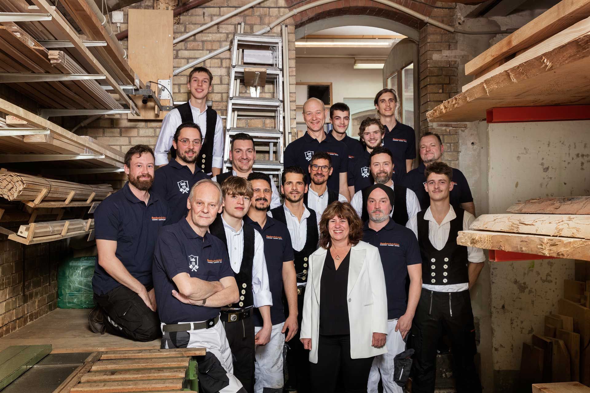 Eine Gruppe von Menschen posiert in einem Lagerhaus für ein Foto.