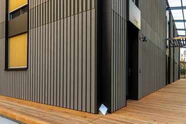 Eine Person verwendet eine Makita-Kettensäge, um ein Stück Holz zu schneiden.