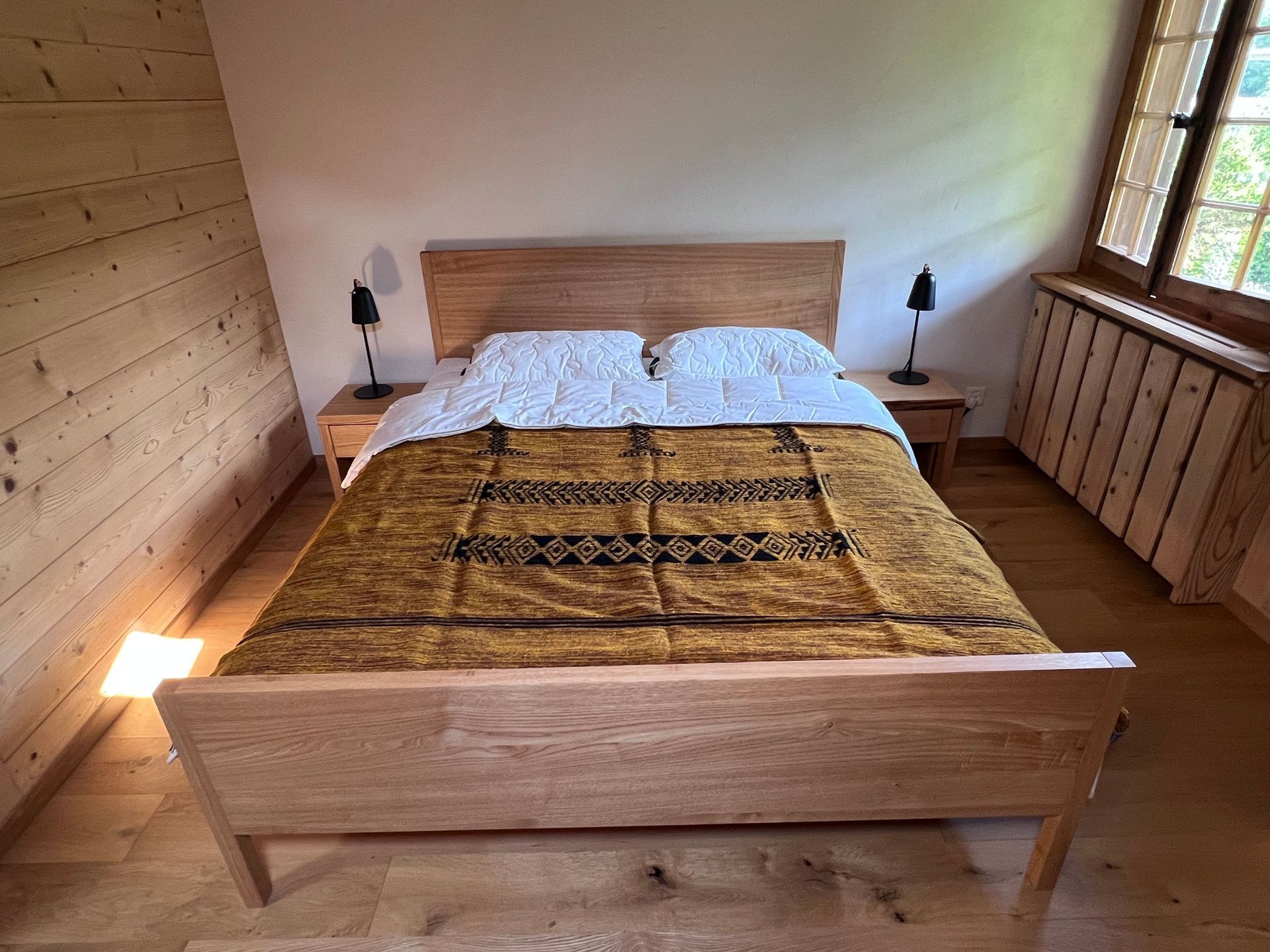 Ein schönes Holzbett in einem Schlafzimmer