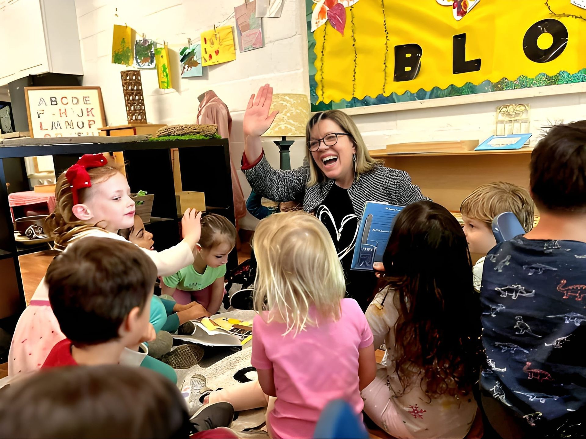 A woman is talking to a group of children in a classroom.