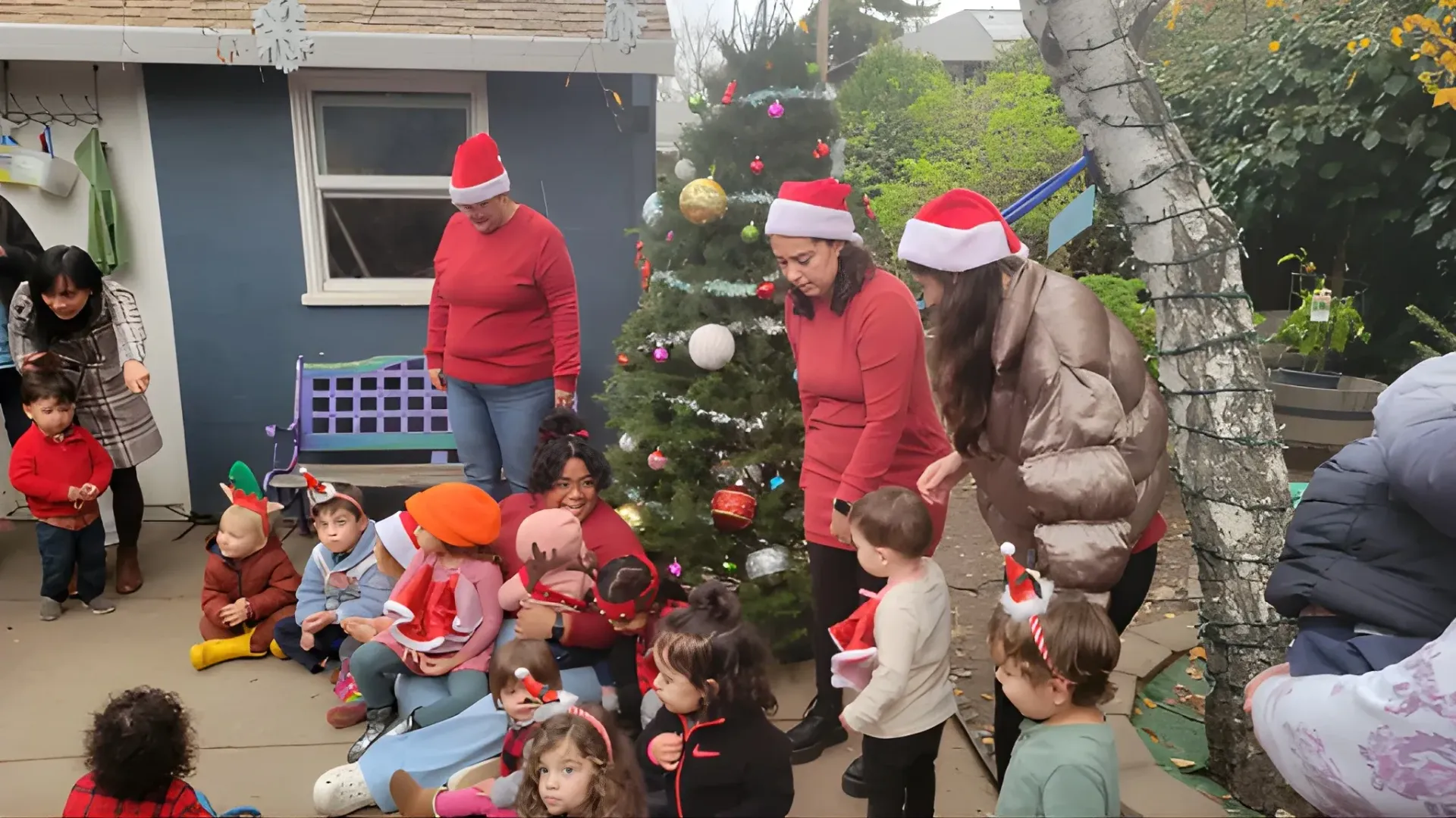 A group of children are standing around a christmas tree.