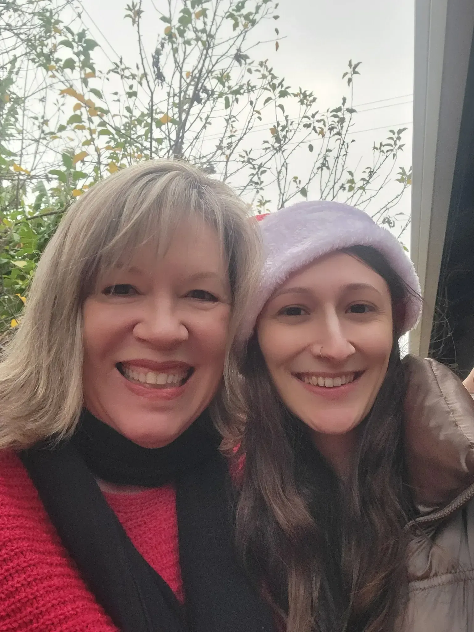 Two women are posing for a picture together and smiling for the camera.