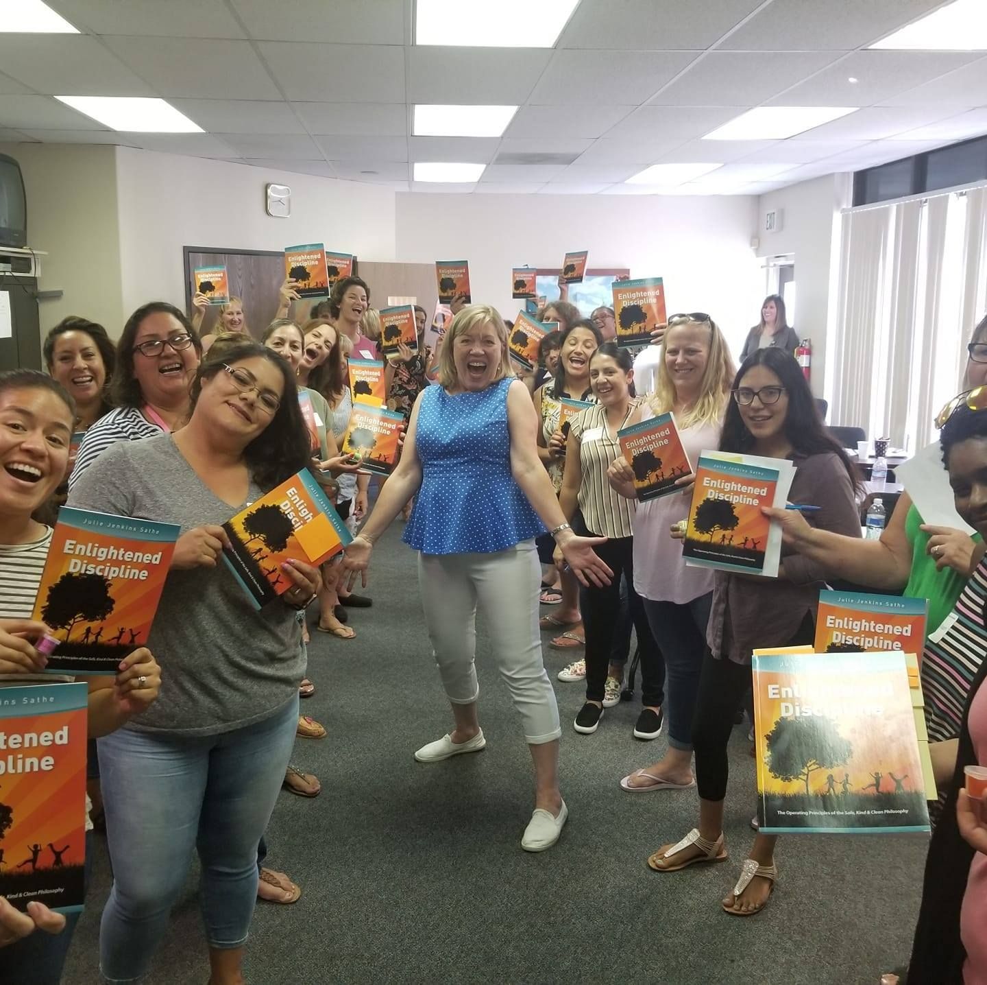 A group of people are posing for a picture while holding a book that says ' a tribute to africa ' on it