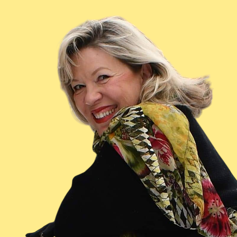 A woman wearing a black shirt and a floral scarf smiles for the camera