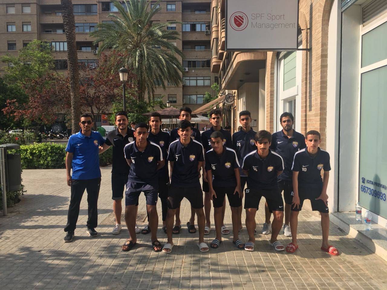 A group of young men are posing for a picture in front of a building.