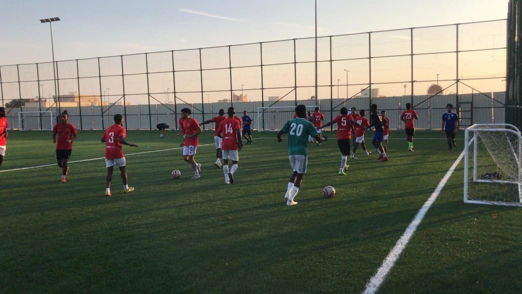 A group of soccer players are playing a game on a field