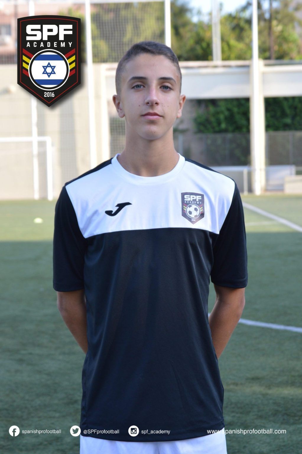 Ori Cohen wearing a black and white soccer jersey is standing on a soccer field.