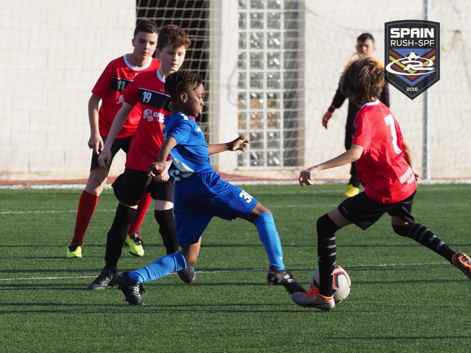 A group of young boys are playing soccer in spain