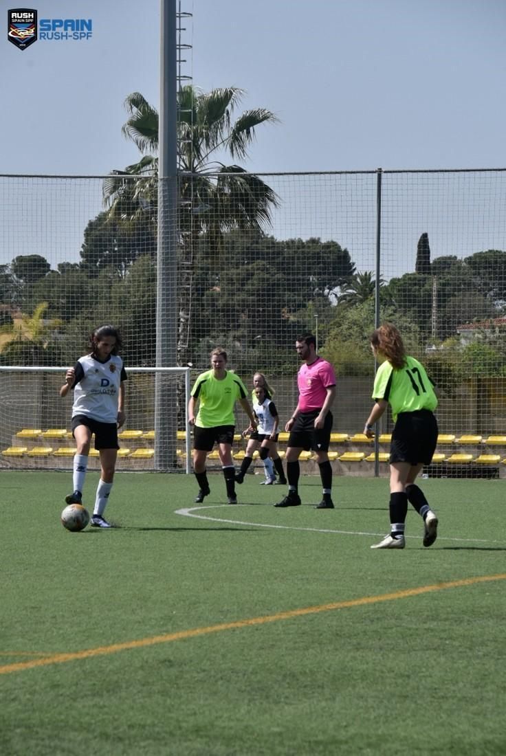 A group of people are playing soccer on a field.