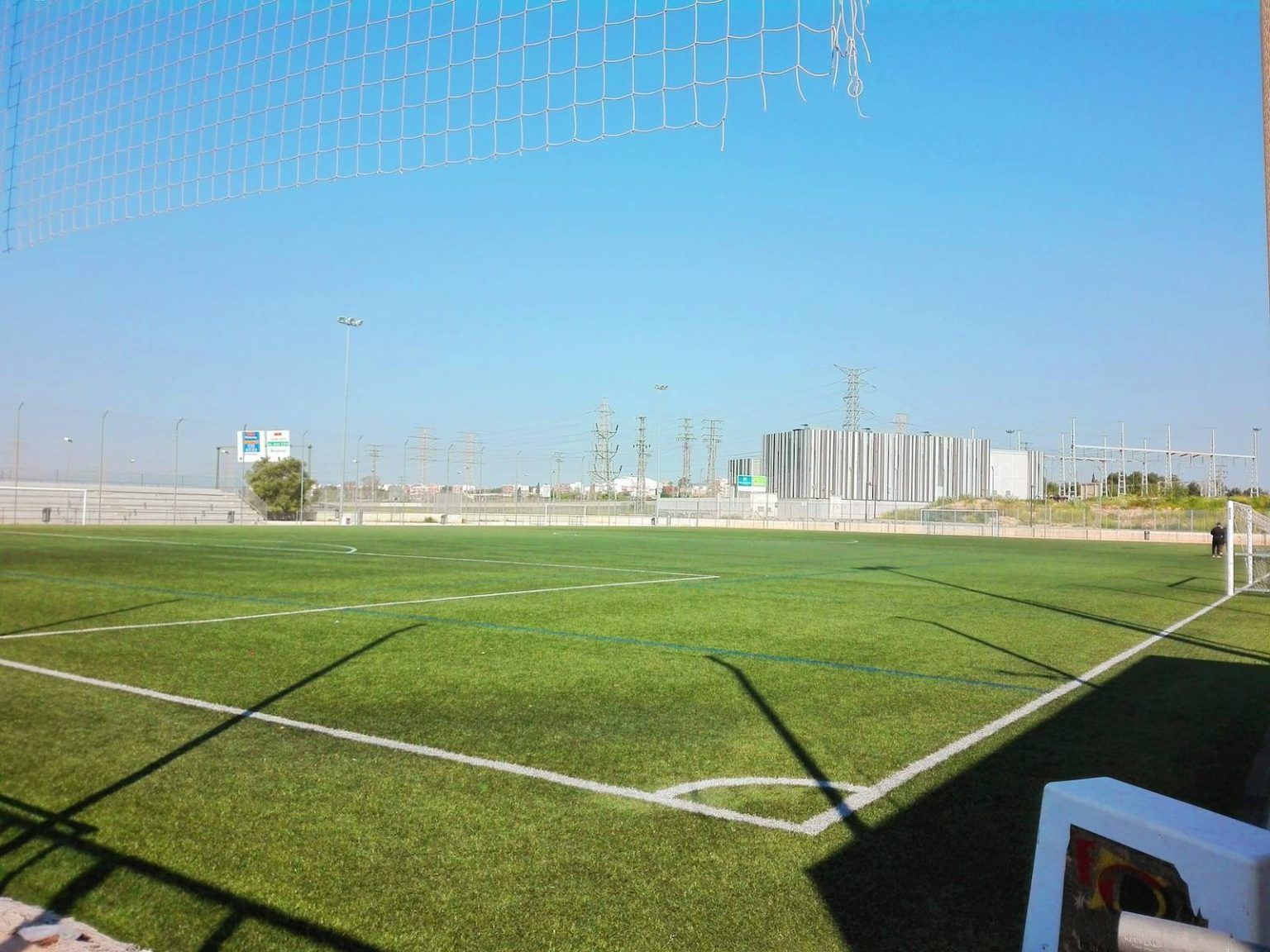 An empty soccer field with a white chair in the foreground.