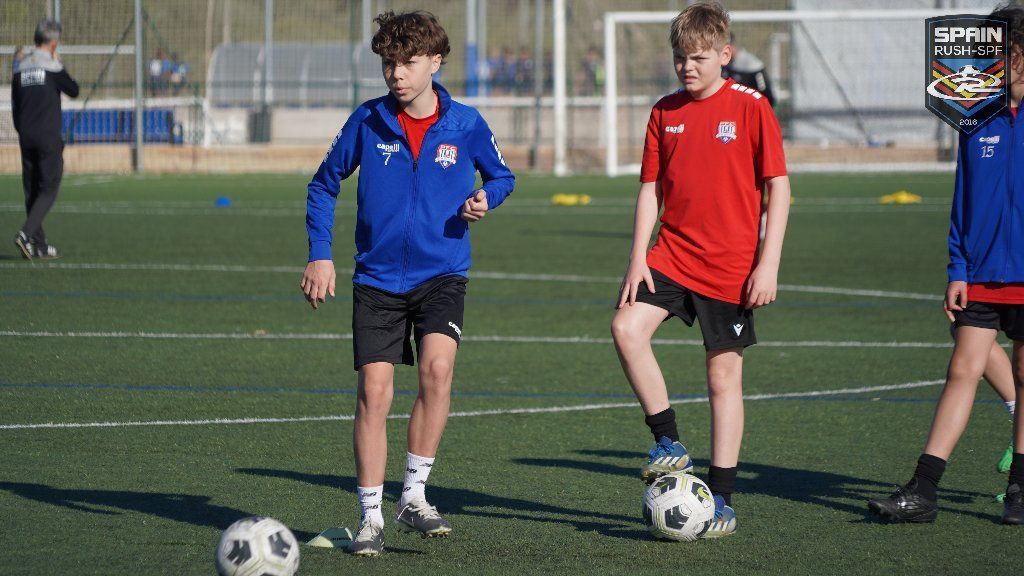 A group of young boys are playing soccer on a field.