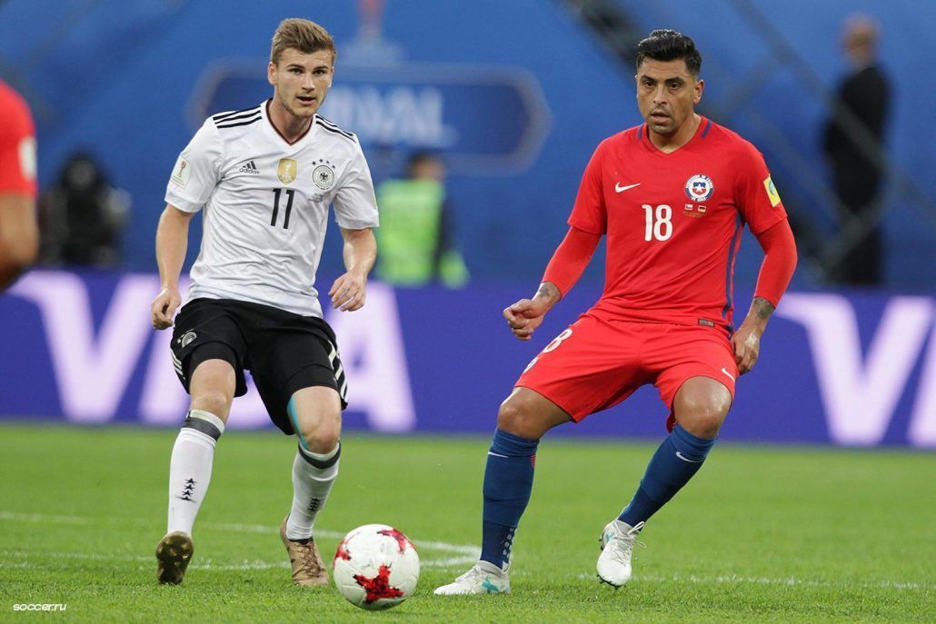 Two soccer players are playing a game of soccer on a field.