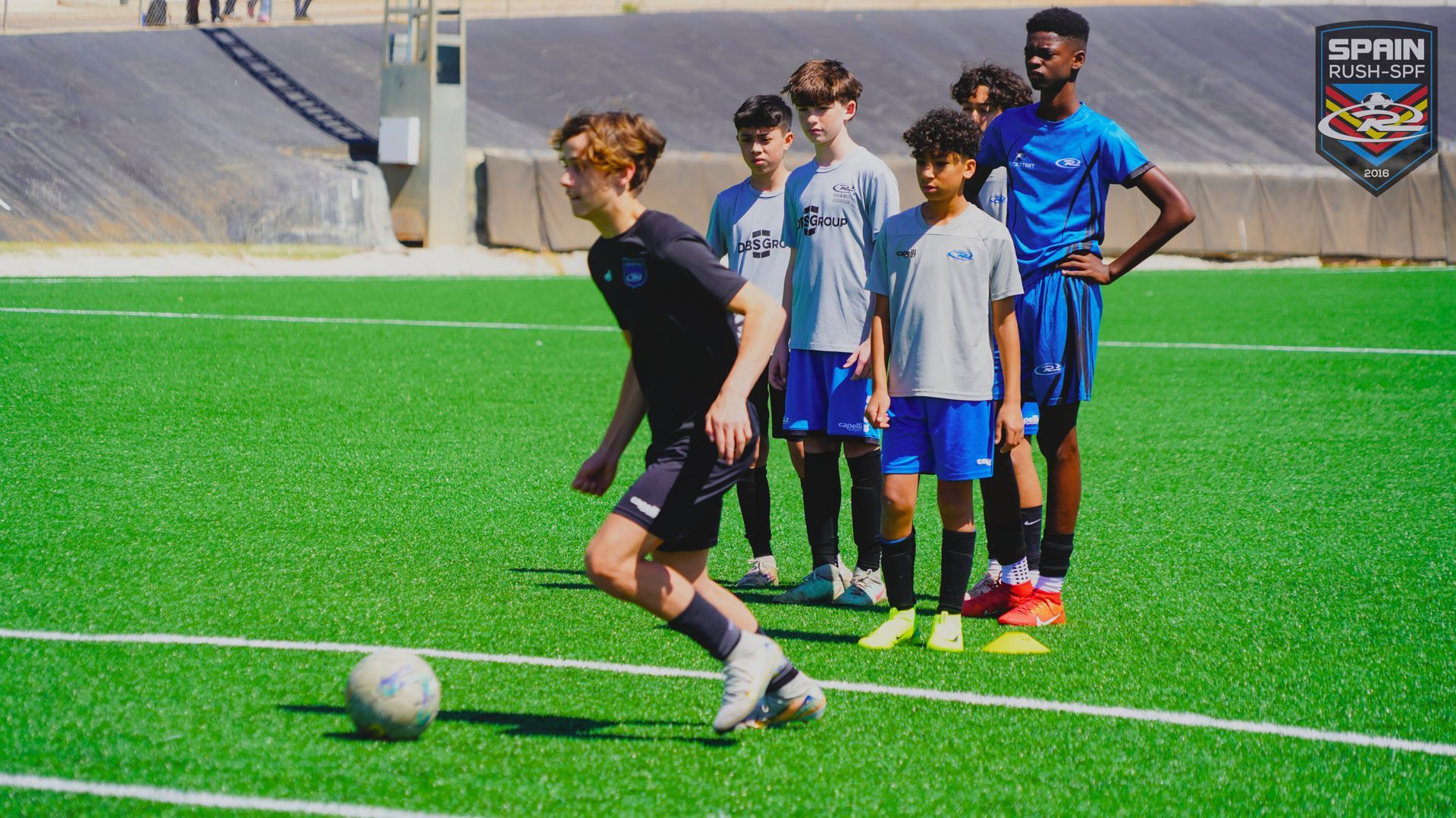 A group of young boys are playing soccer on a field.