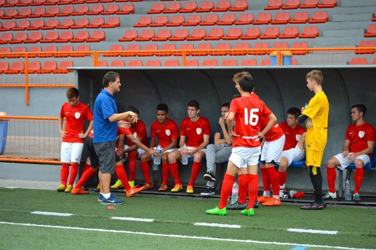 A soccer player with the number 16 on his jersey is talking to a coach