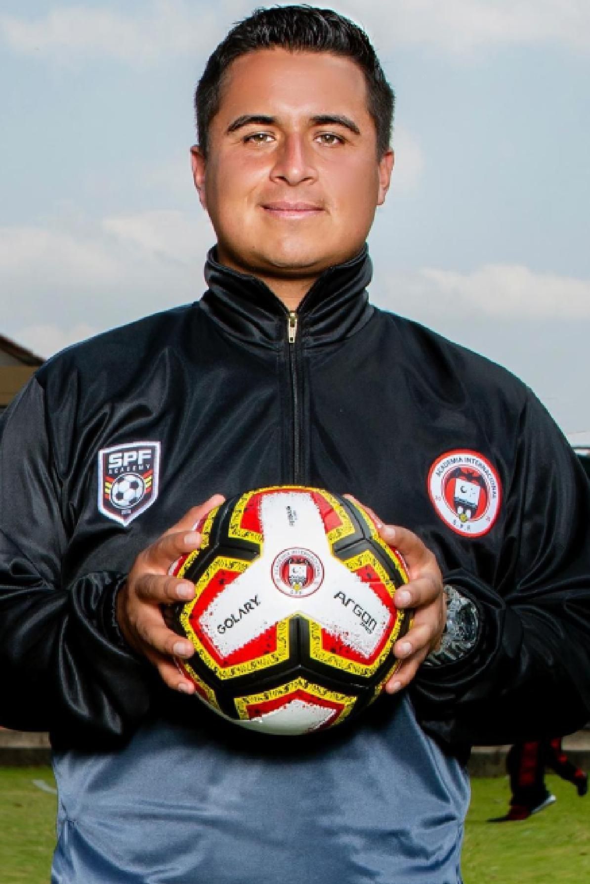 Ferney Alexander Molina in a spf jacket is holding a soccer ball