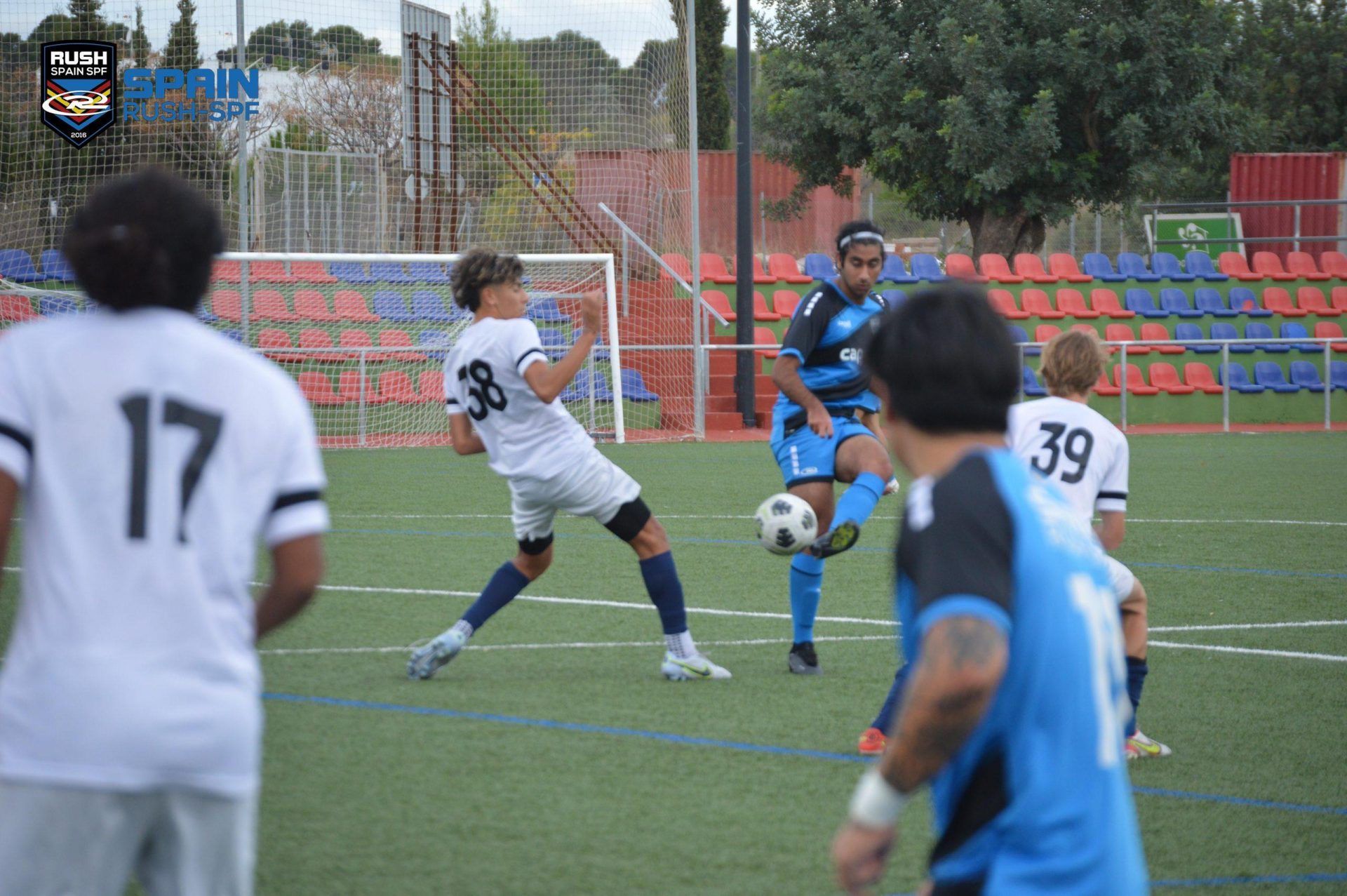 A group of soccer players are playing a game on a field.