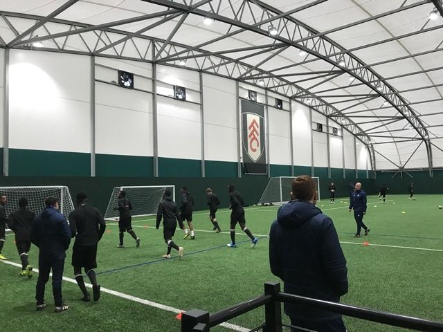 A group of people are playing soccer in an indoor stadium