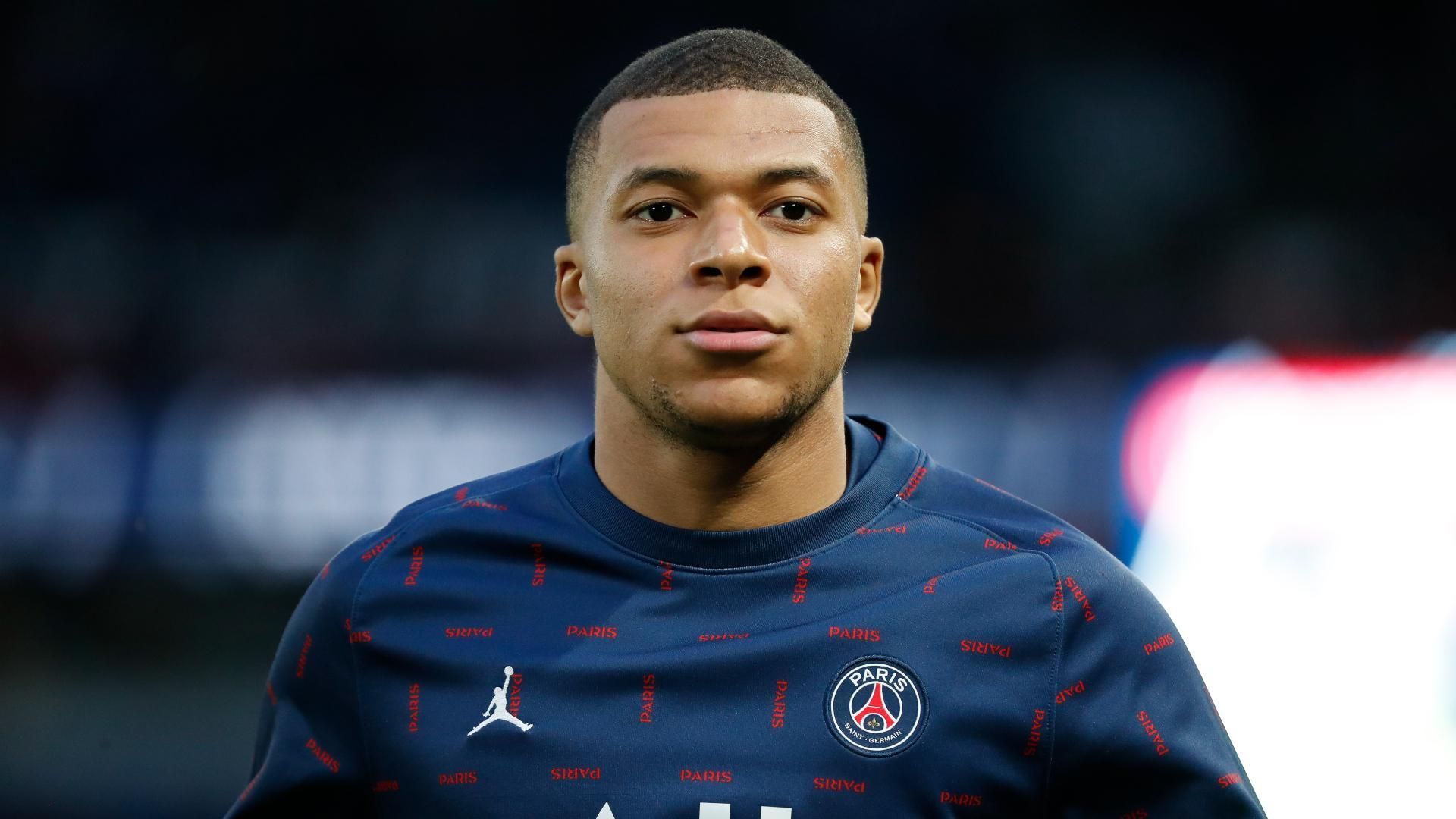 A close up of Kylian Mbappe wearing a blue shirt.