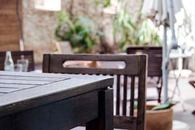 A table and chairs on a patio with an umbrella in the background