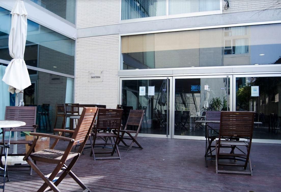 A patio with tables and chairs in front of a building