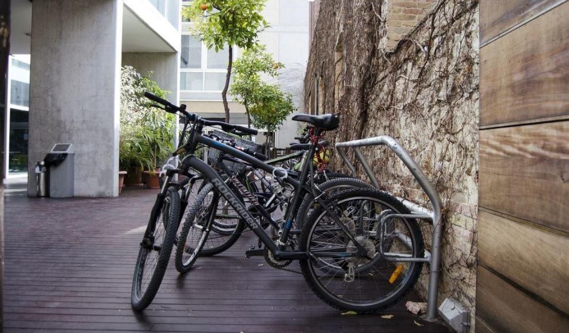 Two bicycles are parked next to each other on a wooden deck.