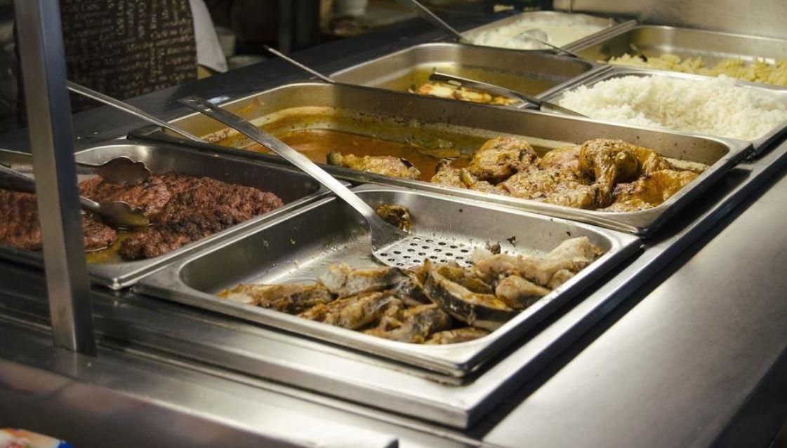 A buffet line with a variety of food on it.