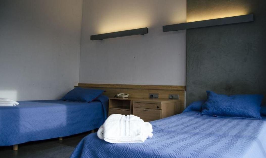 A hotel room with two beds and a nightstand