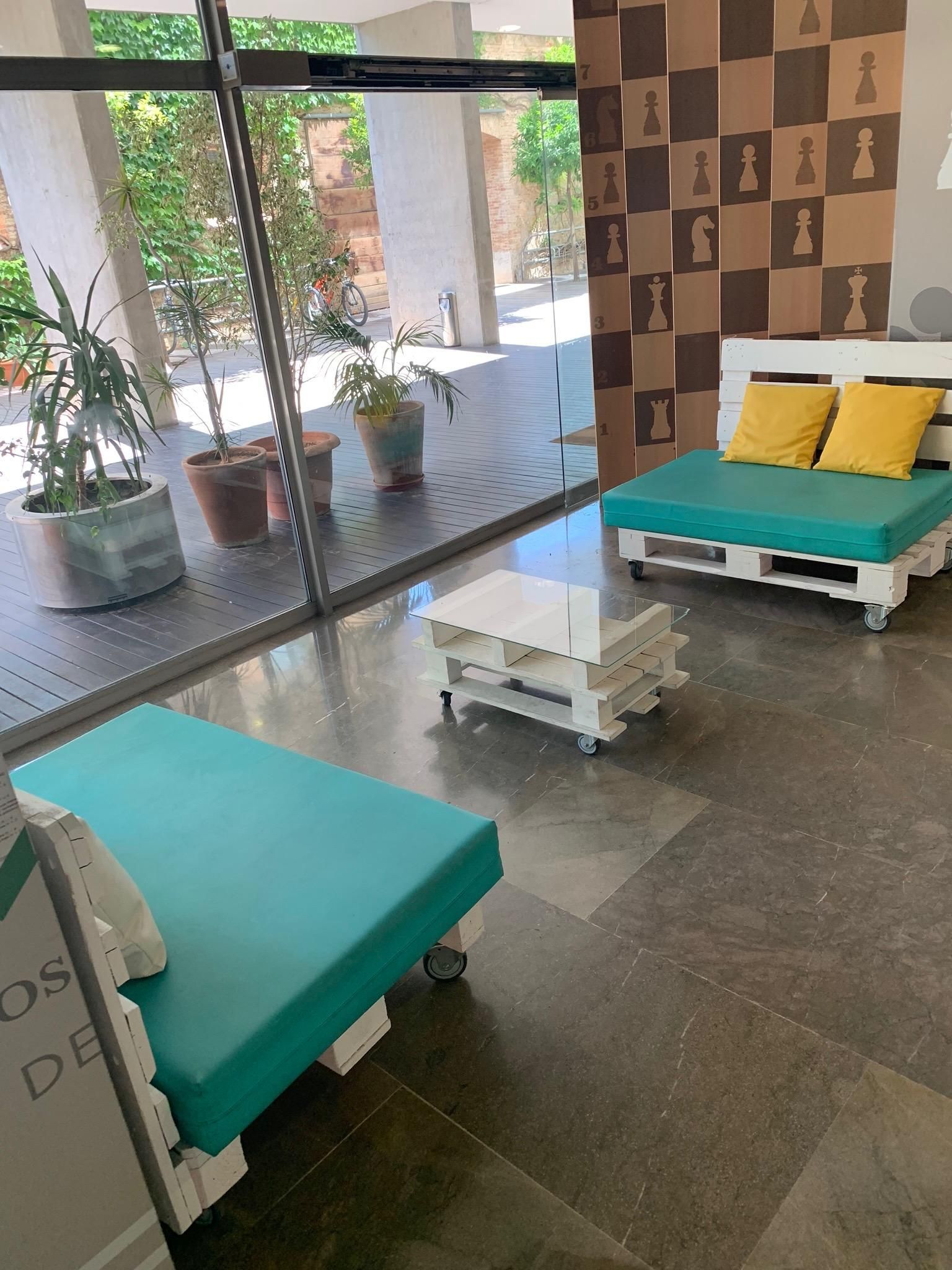 A living room with a lot of furniture and a chess board on the wall.