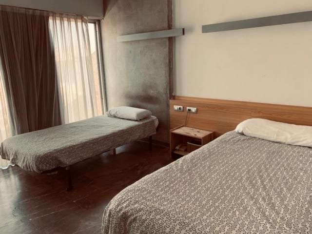 A hotel room with two beds and a window