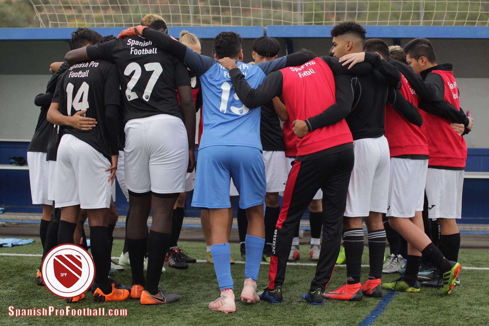 Soccer players huddled together on the sidelines