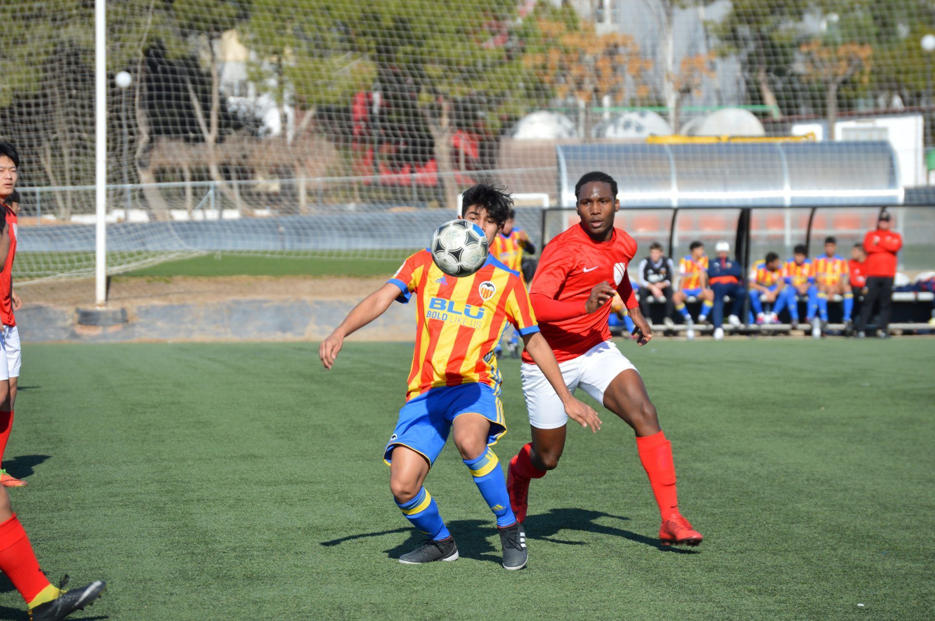 A group of soccer players are playing a game on a field.