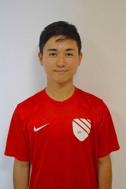 Mahiro Hasegawa wearing a red Nike shirt stands in front of a white wall