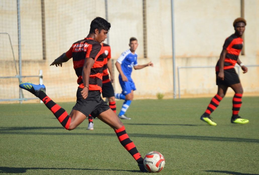 A soccer player kicking a soccer ball on a field