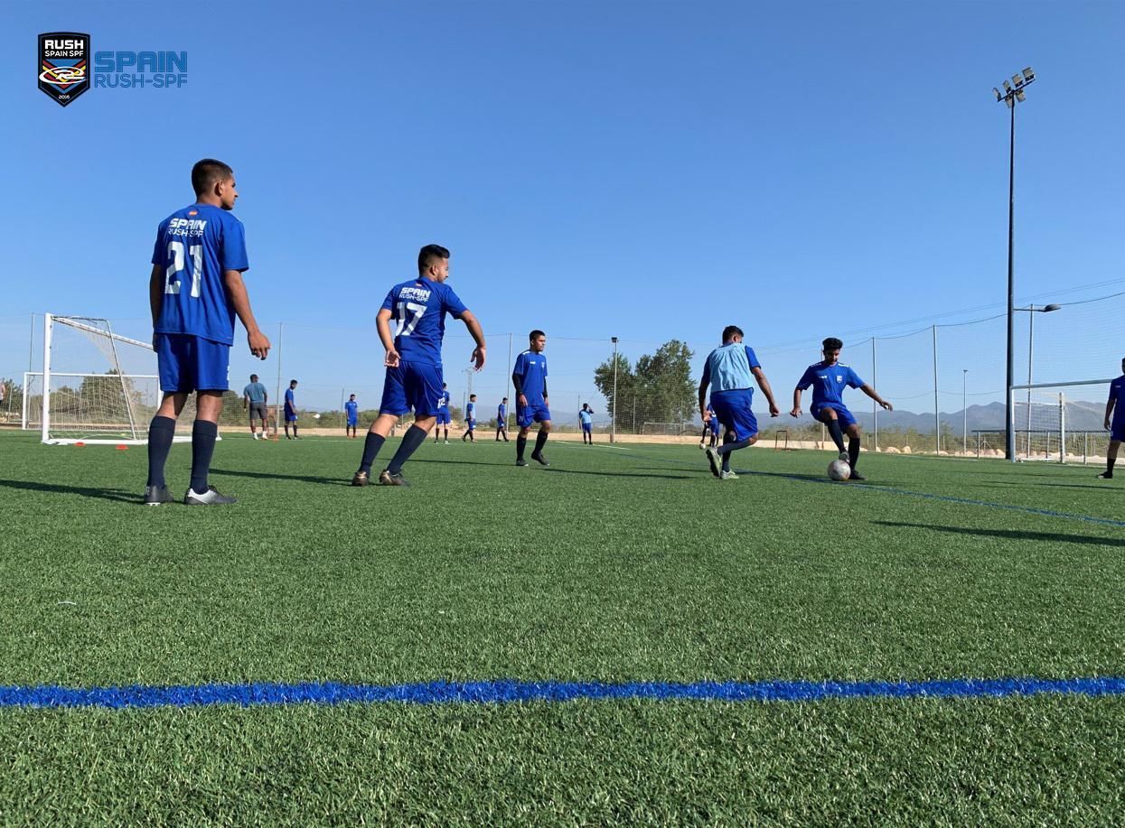 A group of young men are playing soccer on a field.