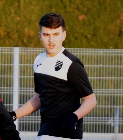 A Swiss man wearing a black and white shirt with a shield on it