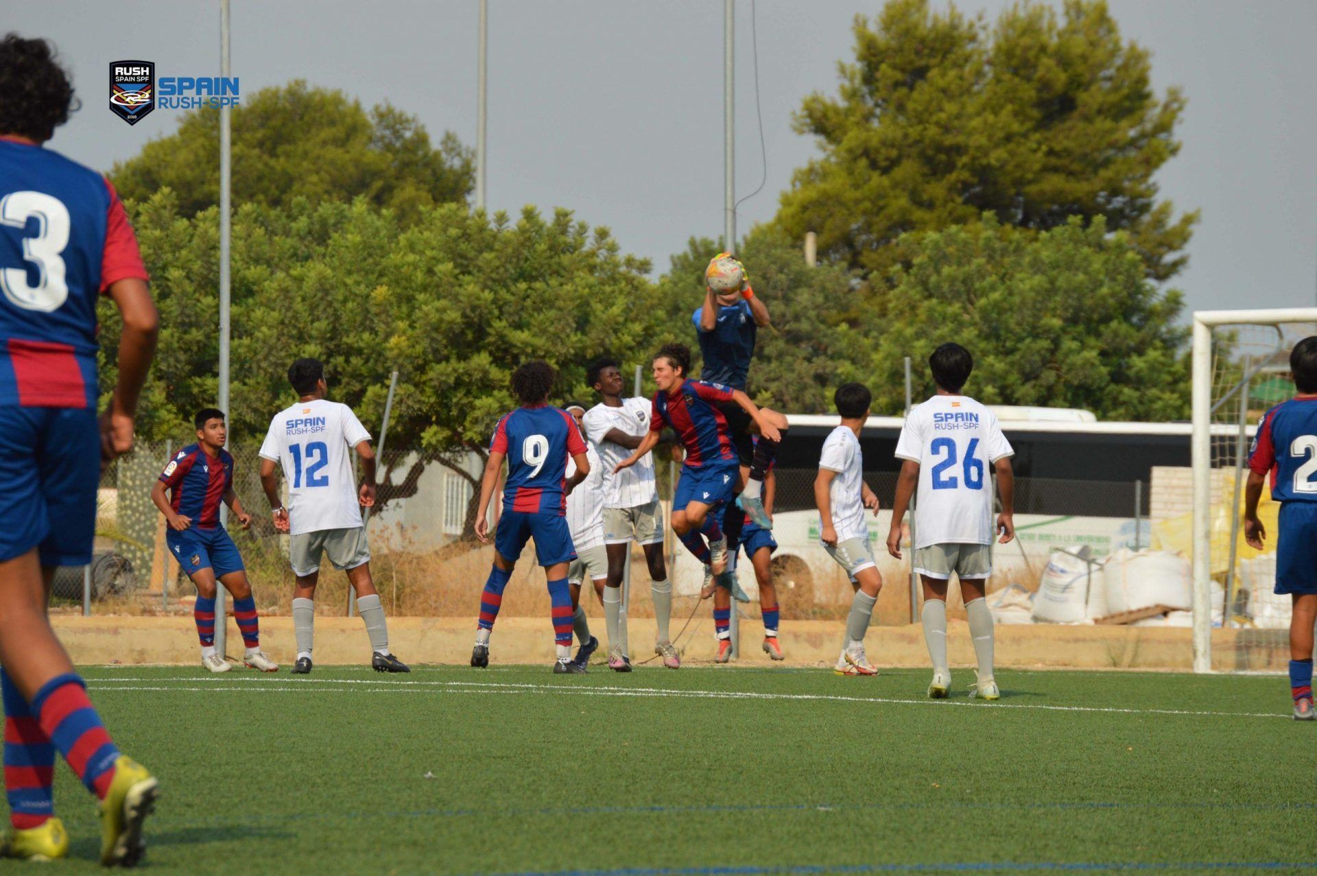 A group of young men are playing soccer on a field.